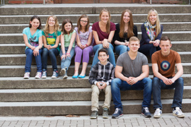 Gruppe von Kindern und Jugendlichen, sitzend auf Stufen